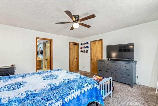 carpeted bedroom featuring a ceiling fan, ensuite bathroom, and a textured ceiling