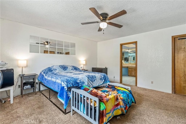 carpeted bedroom featuring ensuite bathroom, a textured ceiling, and a ceiling fan