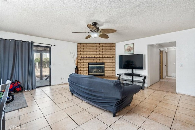 living room with light tile patterned flooring, a fireplace, a textured ceiling, and a ceiling fan