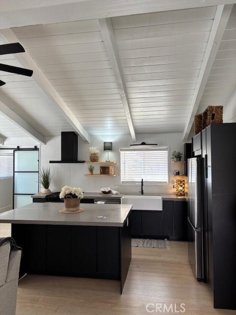 kitchen with a kitchen island, open shelves, a sink, extractor fan, and dark cabinets