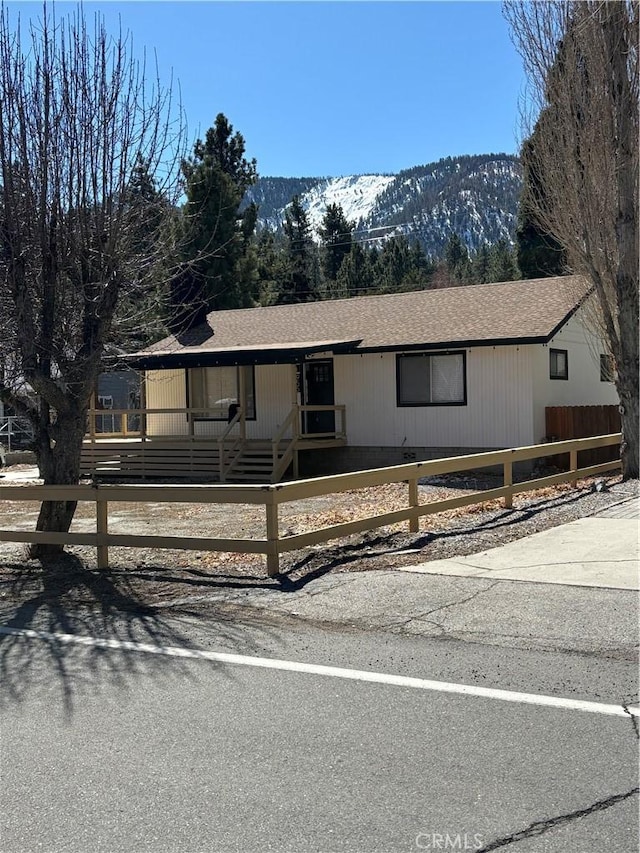 view of front facade featuring a mountain view and roof with shingles