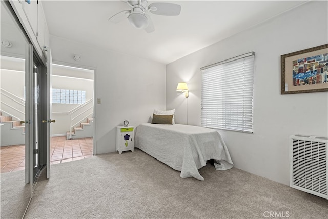 carpeted bedroom with ensuite bath, tile patterned floors, and ceiling fan