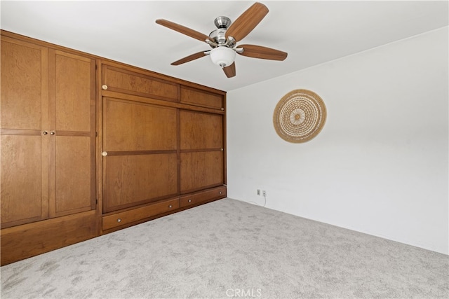 unfurnished bedroom featuring a ceiling fan and carpet