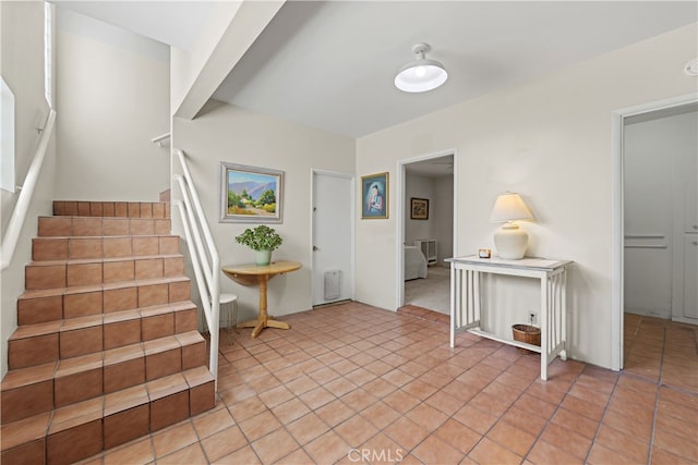 entrance foyer with stairway and light tile patterned flooring