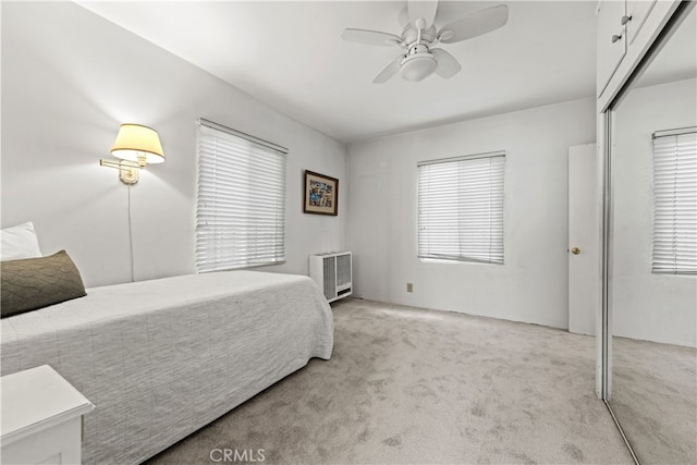 bedroom with ceiling fan, a closet, and light carpet