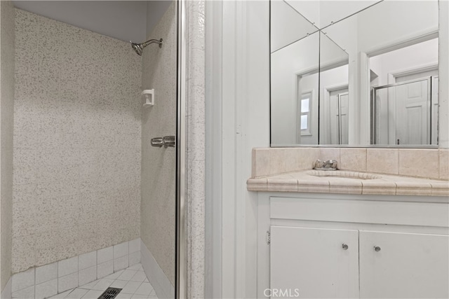 full bath featuring vanity and a shower stall