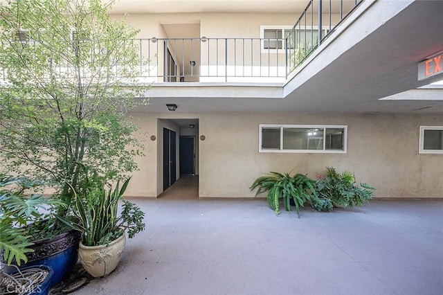 doorway to property with a patio area, stucco siding, and a balcony