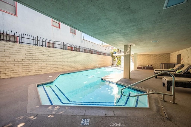 indoor pool featuring electric panel, a patio, and fence