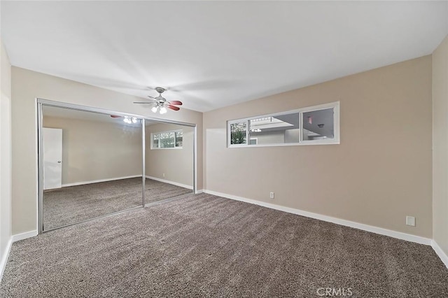 unfurnished bedroom with a closet, carpet floors, baseboards, and ceiling fan