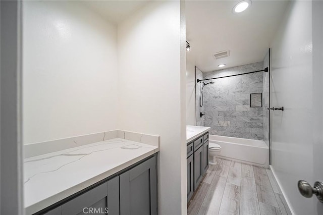 bathroom with vanity, wood finished floors, visible vents, shower / bath combination, and toilet