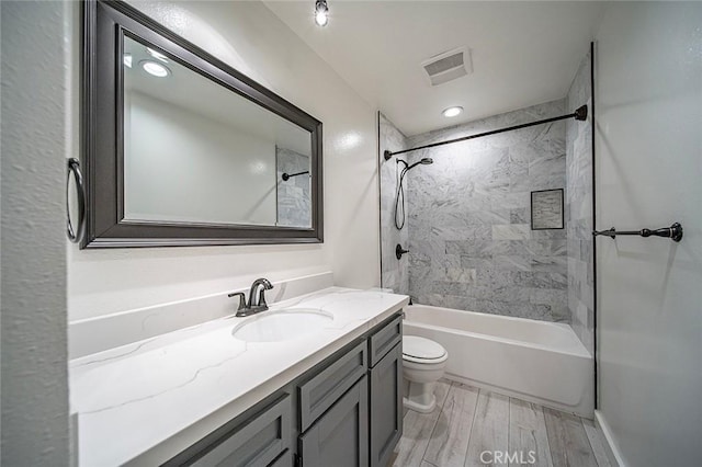 bathroom with vanity, wood finished floors, visible vents, shower / bath combination, and toilet