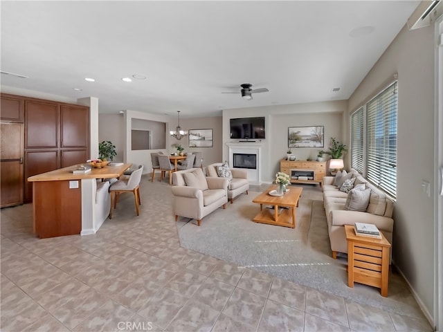 living room with a ceiling fan, visible vents, baseboards, recessed lighting, and a glass covered fireplace