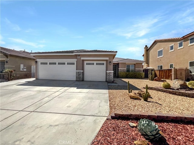 view of front of house featuring stone siding, stucco siding, concrete driveway, and fence