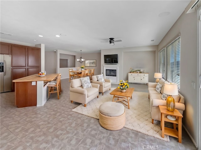 living area featuring a glass covered fireplace, recessed lighting, a ceiling fan, and visible vents