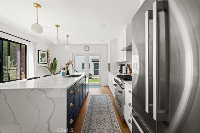 3345 Oakhurst Ave, Los Angeles, CA 90034 - kitchen featuring stainless steel appliances, blue cabinetry, white cabinets, a sink, and light wood-style flooring