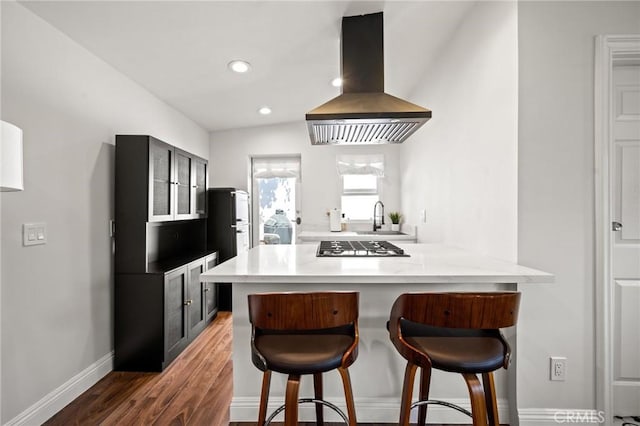3345 Oakhurst Ave, Los Angeles, CA 90034 - kitchen with island exhaust hood, a breakfast bar, a sink, wood finished floors, and a peninsula