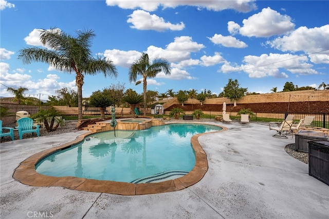 view of pool featuring a pool with connected hot tub, a fenced backyard, and a patio area