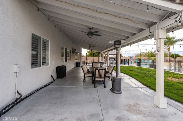 view of patio featuring outdoor dining space, fence, and a ceiling fan