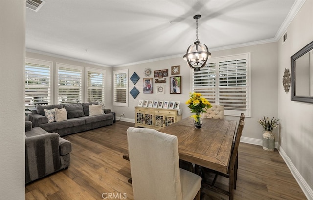 dining area featuring ornamental molding, wood finished floors, visible vents, and a chandelier