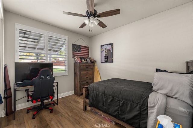 bedroom with a ceiling fan, baseboards, and wood finished floors