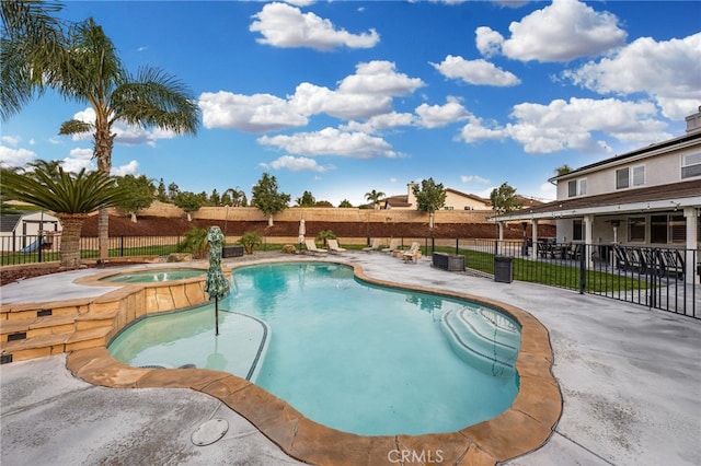 view of pool with a patio, a pool with connected hot tub, and fence