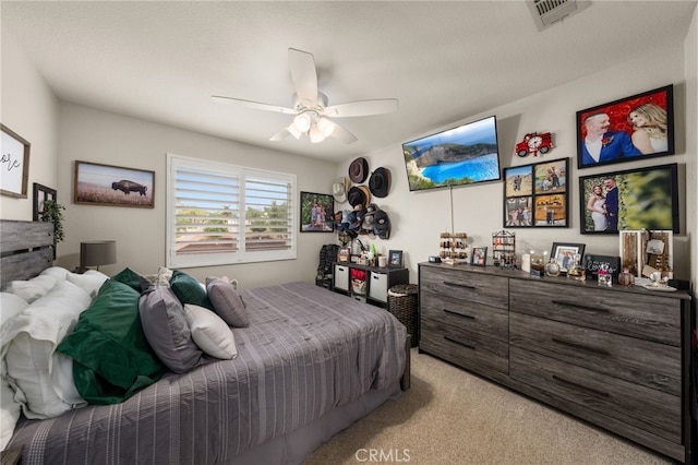 bedroom with light colored carpet, visible vents, and ceiling fan