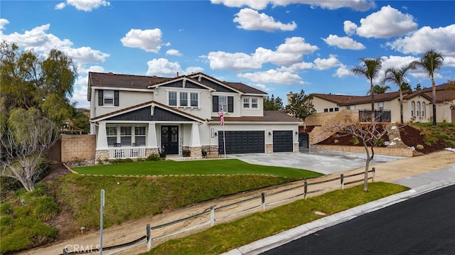 view of front of home with a front yard, fence, driveway, stucco siding, and stone siding