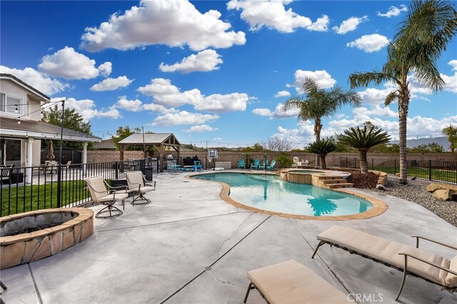 view of swimming pool with a gazebo, fence, a pool with connected hot tub, and a patio area