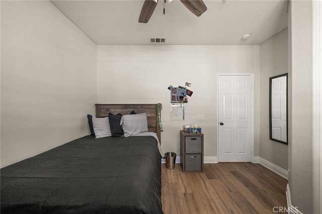 bedroom featuring visible vents, baseboards, wood finished floors, and a ceiling fan