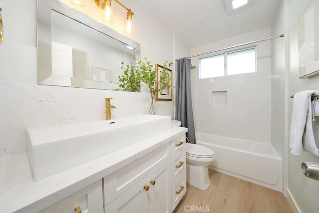 full bathroom with vanity, toilet, wood finished floors, and shower / tub combo with curtain