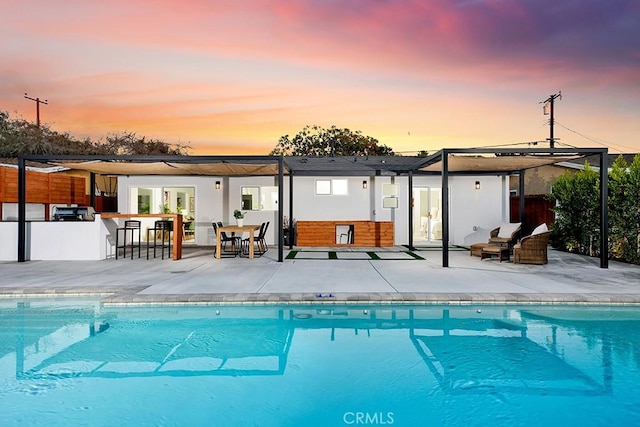 rear view of house with a patio area, an outdoor pool, and outdoor dry bar