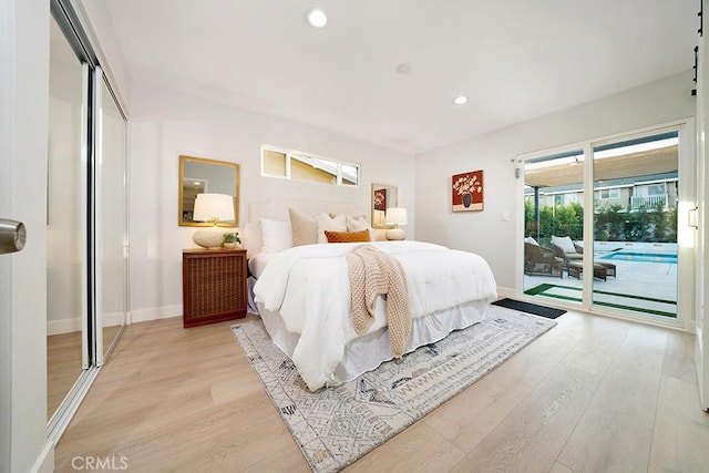 bedroom featuring access to exterior, baseboards, and light wood-type flooring