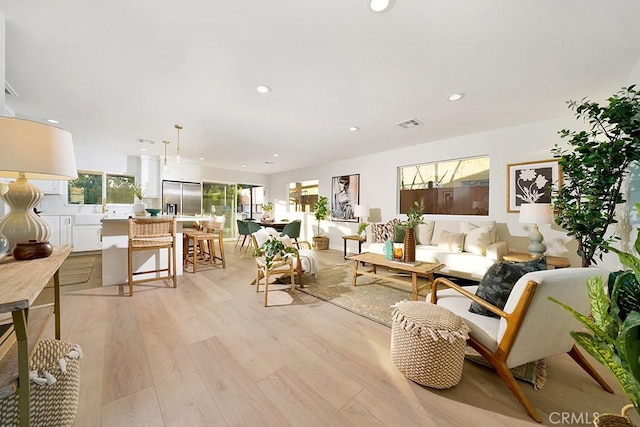 living area featuring recessed lighting, plenty of natural light, and light wood-style flooring