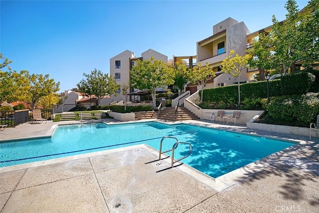 pool featuring fence and a patio area