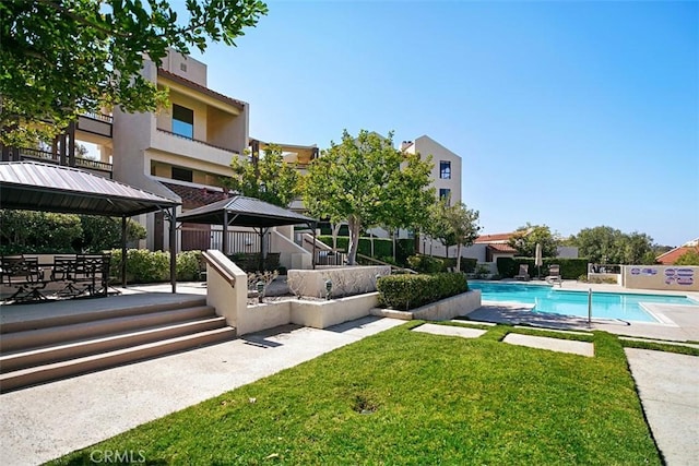 pool with a patio area, a yard, and fence