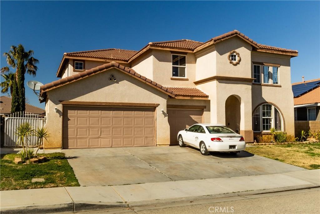 mediterranean / spanish-style house with stucco siding, driveway, fence, a garage, and a tiled roof