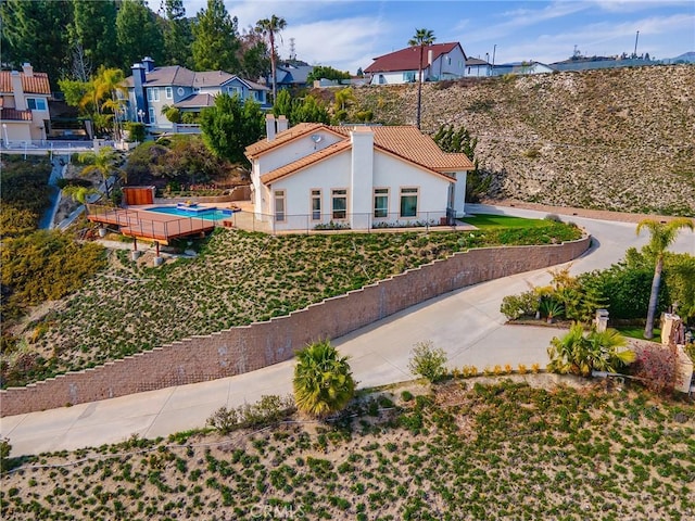 exterior space with a residential view, stucco siding, a tile roof, and fence