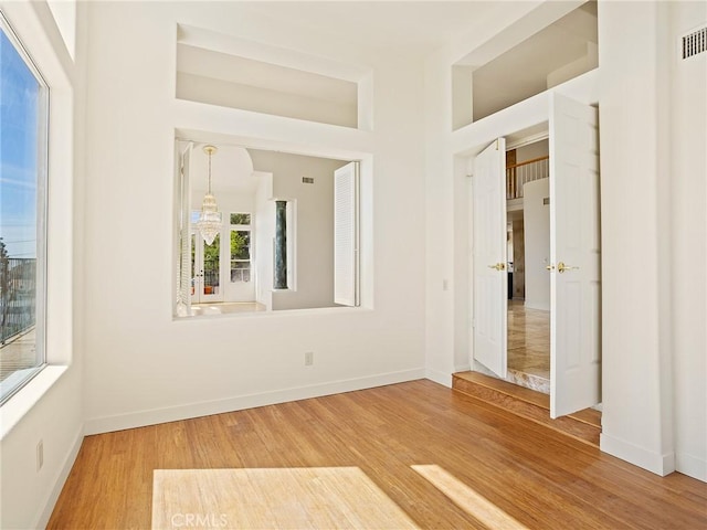 empty room featuring visible vents, baseboards, and wood finished floors