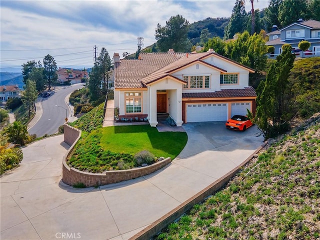 view of front of property with a tile roof, a front yard, a garage, and driveway