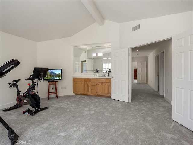 workout area featuring baseboards, visible vents, lofted ceiling, and light carpet