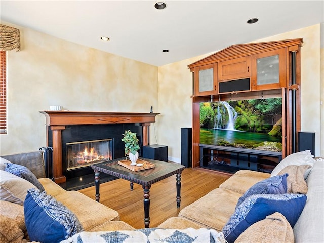 living area with recessed lighting, wood finished floors, and a fireplace