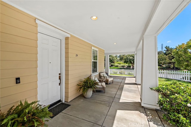 property entrance featuring a porch and fence