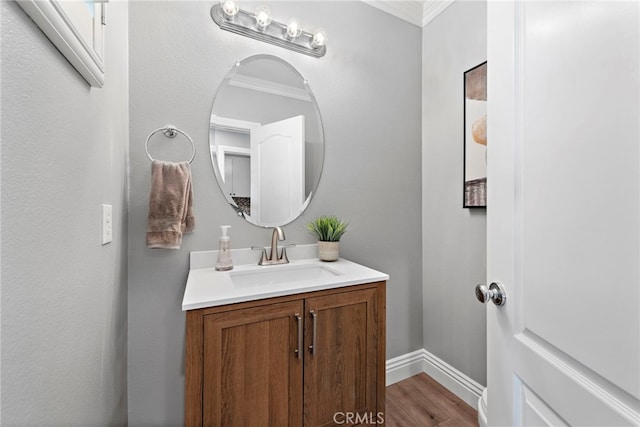 bathroom featuring ornamental molding, vanity, baseboards, and wood finished floors