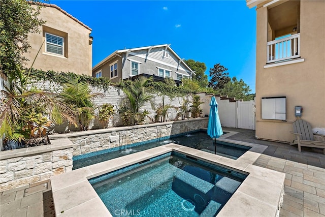 view of pool featuring a patio area, an in ground hot tub, and a fenced backyard