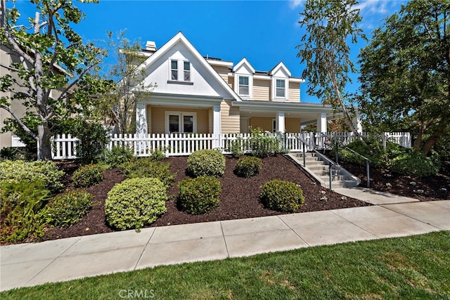 view of front facade featuring fence and covered porch