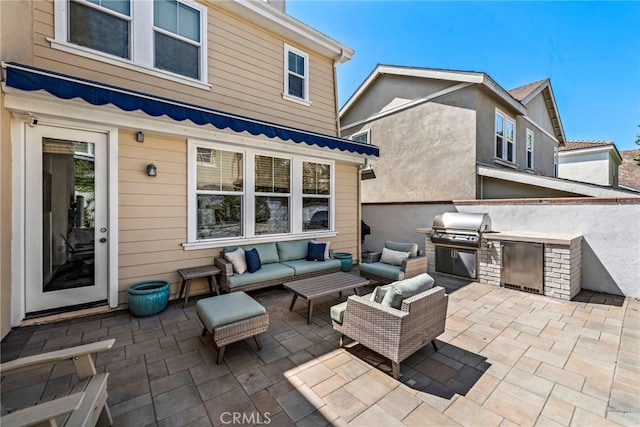 view of patio with area for grilling, an outdoor hangout area, and exterior kitchen