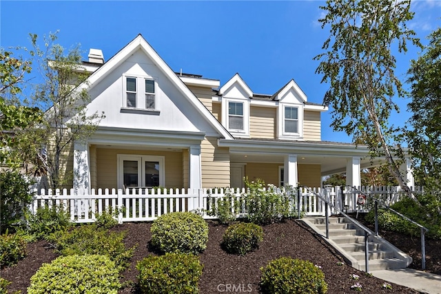 view of front of house with covered porch and a fenced front yard