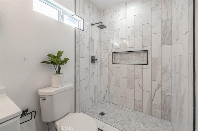 full bathroom with tiled shower, toilet, and vanity