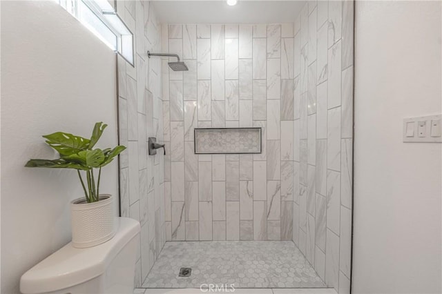 bathroom featuring toilet and a tile shower