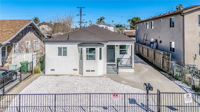 back of property with crawl space, stucco siding, a shingled roof, and fence